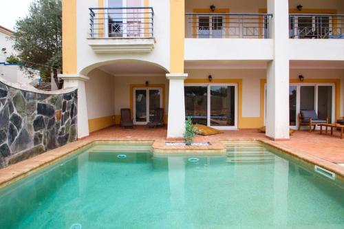 a swimming pool in front of a house at Casa da Barragem da Vigia in Redondo