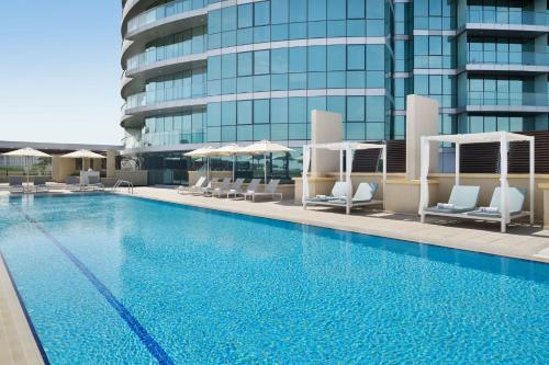 a large swimming pool with chairs and a building at InterContinental Residence Suites Dubai Festival City by IHG in Dubai