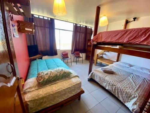 un dormitorio con dos camas y una litera en Surf House Chicama, en Puerto Chicama