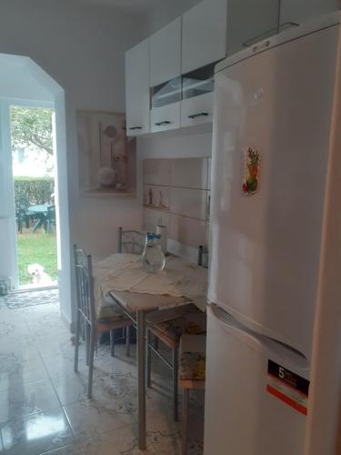 a kitchen with a table and a refrigerator at Apartament PARTER CU GRADINA in Slănic-Moldova