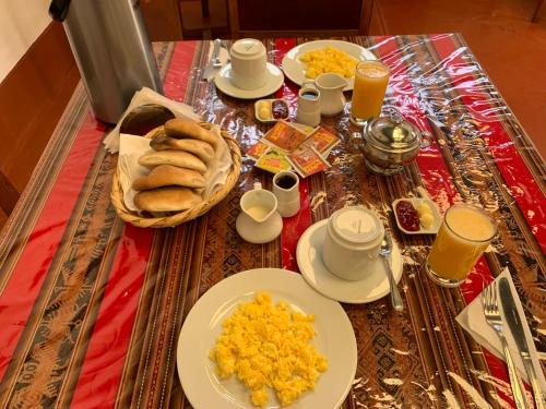 een tafel met borden eten en kopjes koffie bij Hospedaje Killipata in Cuzco
