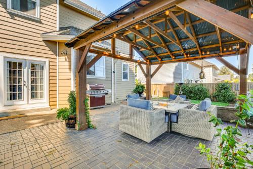 a pergola with chairs and a table on a patio at 6 Mi to Autzen Stadium Family Home with Hot Tub! in Eugene