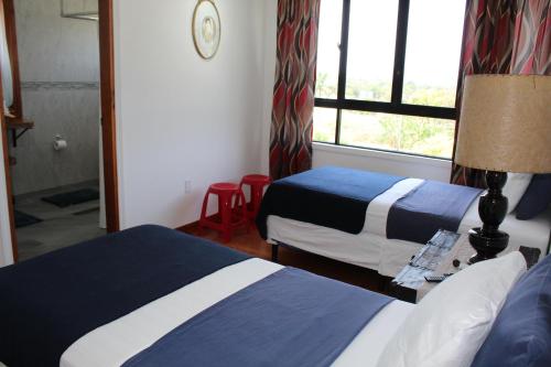 a hotel room with two beds and a window at CAJOMA Villa 1 in San Ignacio