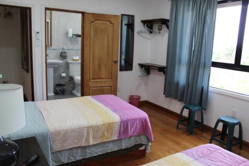 a hotel room with two beds and a bathroom at CAJOMA Villa 1 in San Ignacio