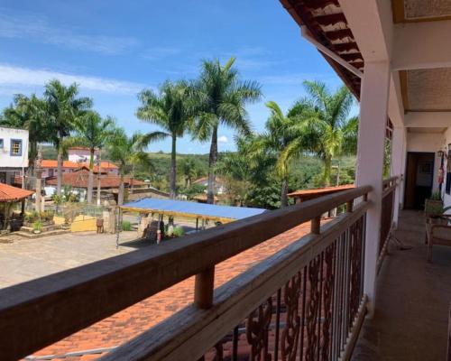 d'un balcon avec des palmiers en arrière-plan. dans l'établissement Pousada Santo Antônio Tiradentes 400m Maria Fumaça 2º Andar, à Tiradentes