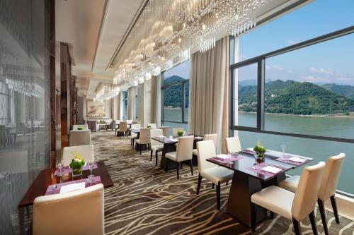 a restaurant with tables and chairs and a large window at Crowne Plaza Yichang by IHG in Yichang