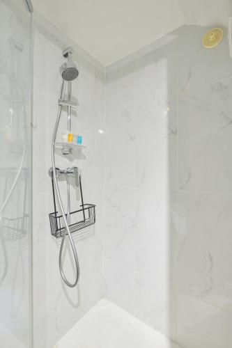 une salle de bain avec une douche avec pommeau de douche dans l'établissement Super 3 pièces Paris Centre, à Paris