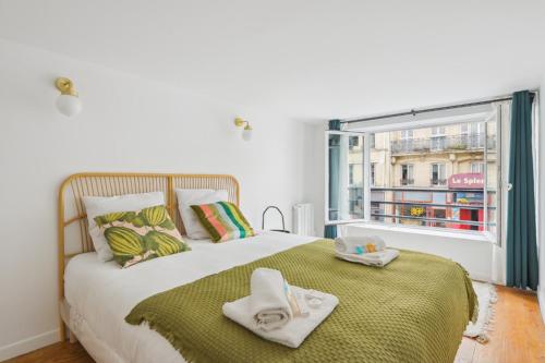 une chambre avec un grand lit avec des serviettes dessus dans l'établissement Super 3 pièces Paris Centre, à Paris