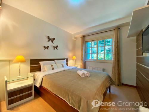 a bedroom with a bed with two butterflies on the wall at Apartamento 1 dormitório a 150m do Mini Mundo in Gramado