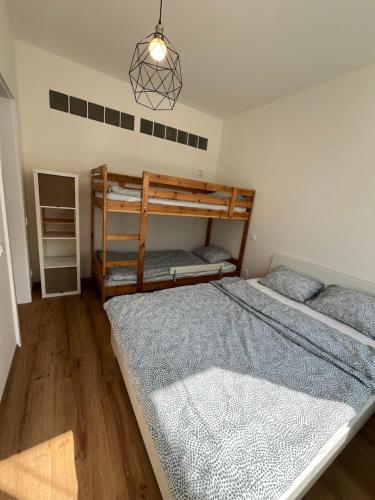 a bedroom with two bunk beds and a chandelier at Rodinný Apartmán U Pralesa in Černé Údolí