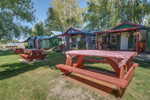 a picnic table in front of a group of houses at Resort Cabin on the River about 21 Mi to Crater Lake! in Chiloquin