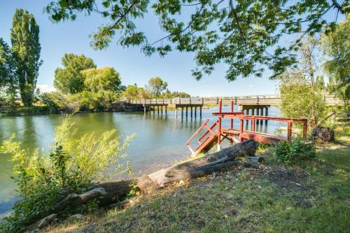 a dock on a river with a bridge at Resort Cabin on the River about 21 Mi to Crater Lake! in Chiloquin