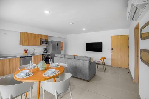 a kitchen and living room with a table and chairs at Upstay - New Condo in Jaco - 5 mins from Beach in Jacó
