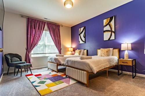 a purple bedroom with two beds and a chair at Raleigh Luxe Family Retreat- 15 Min to Downtown, Kids Gear, Fast WiFi for WFH, EV & Pet Friendly in Raleigh