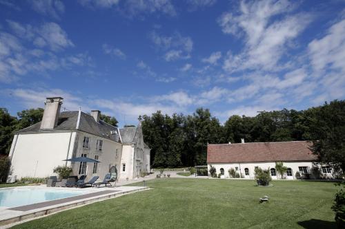 a large white house with a swimming pool in the yard at Chambres d'hôtes chez Sylvie in Donnemain-Saint-Mamès