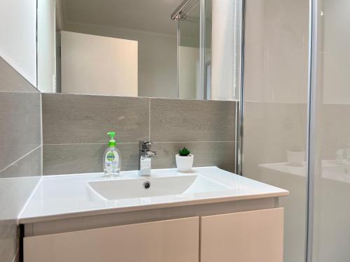 a bathroom with a white sink and a mirror at Quiet, private and 5-bedroom holiday house in Hamilton