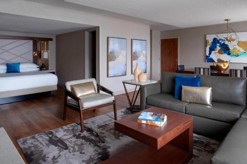 a living room with a couch and a bed at Kansas City Airport Marriott in Kansas City