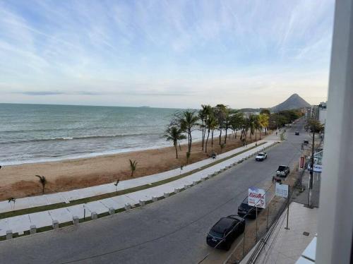 a view of a street and the ocean with palm trees at Vista Mar em PIÚMA in Itapitanga