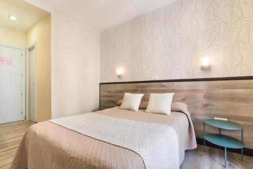 a bedroom with a large bed and two tables at Hostal Art Madrid in Madrid