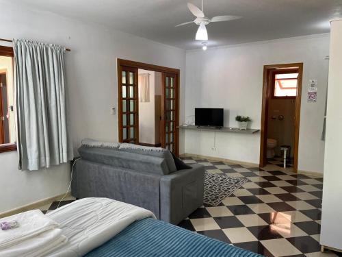 a living room with a couch and a tv at Mansão Adalgisa in Osasco