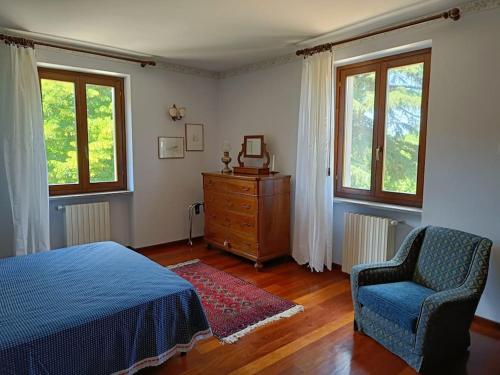une chambre avec un lit, une chaise et des fenêtres dans l'établissement Casale la Quercia - Splendido casale nella natura, à Cura