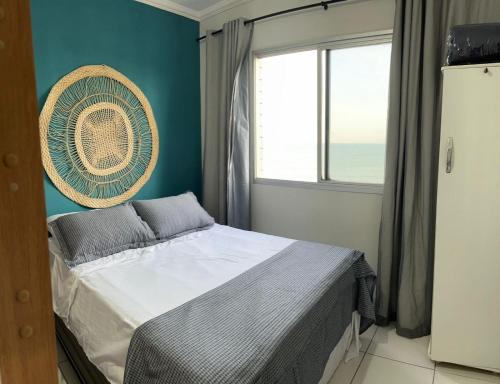 a bedroom with a bed and a window with the ocean at Vista Mar em PIÚMA in Itapitanga