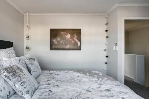 a bedroom with a bed and a picture on the wall at Contemporary Townhouse in Central Hamilton in Claudelands