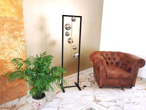 a leather chair and a plant in a room at Spirit of Gozo unique penthouse in Xagħra