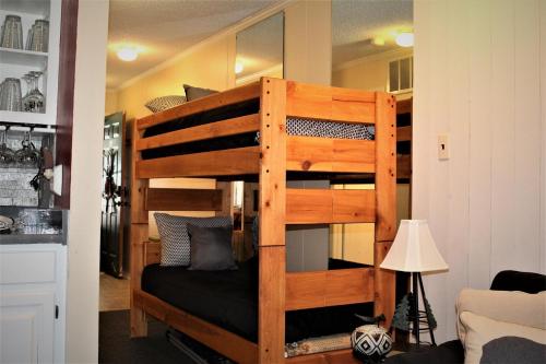 a wooden bunk bed in a room with a lamp at Bear Canyon Condo #129 in Ruidoso