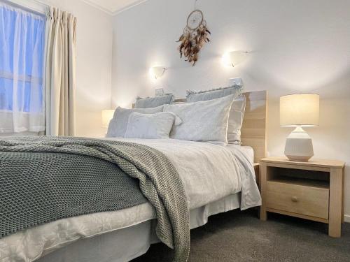 a bedroom with a bed and a clock on the wall at Quiet, private and 5-bedroom holiday house in Hamilton