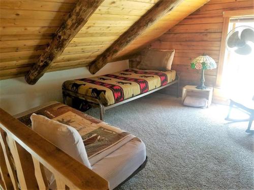 a bedroom with two beds in a log cabin at Bearadise in Ruidoso