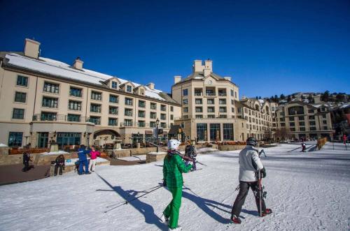 a group of people on skis in front of a building at Ascent 206 by East West Hospitality in Avon