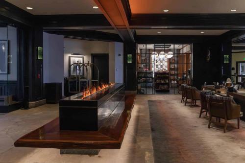 a restaurant with a fireplace in the middle of a lobby at Ascent 312 by East West Hospitality in Avon