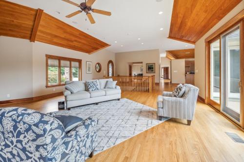 a living room with two couches and a ceiling fan at Hidden Waterfront Luxury Oasis with 9-Acre Pond home in Sandston