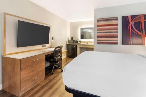 a hotel room with a bed and a desk with a television at Best Western Plus Rancho Cordova Inn in Rancho Cordova