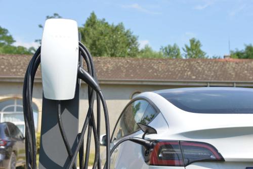 a white car parked next to a charging station at Best Western Golf d'Albon in Albon