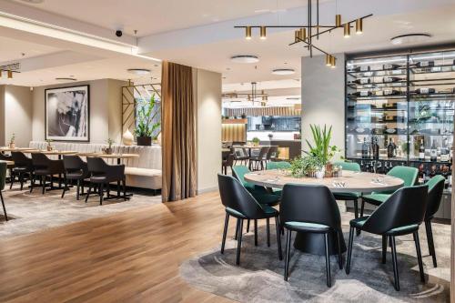 a restaurant with tables and chairs and a bar at Radisson Hotel Kaunas in Kaunas