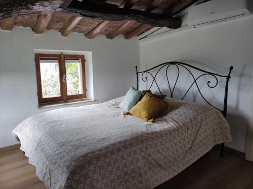 a white bedroom with a bed with two pillows on it at Mozzafiato Casa Collina in Conzano