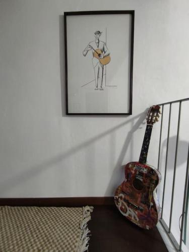 a guitar next to a picture of a man holding a guitar at Mozzafiato Casa Collina in Conzano