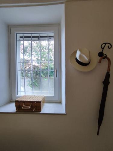 a window with a hat and a gun on a wall at Mozzafiato Casa Collina in Conzano