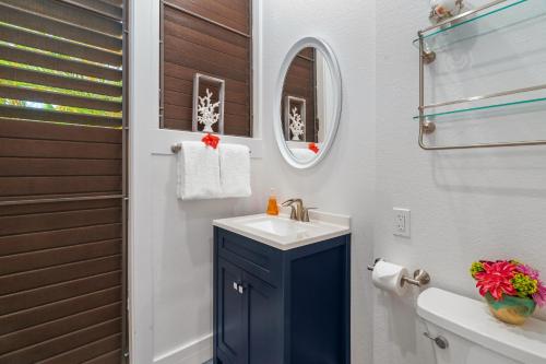 a bathroom with a sink and a toilet and a mirror at Beautiful 2br condo with partial ocean view in Koloa