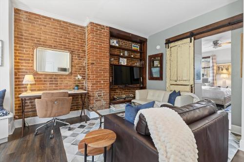 a living room with a couch and a brick wall at Beautiful 1-BR Flat Nestled Between Dupont & Logan in Washington, D.C.