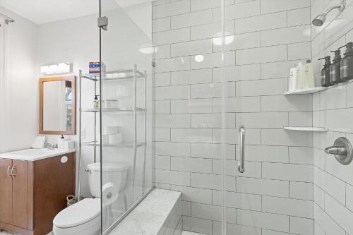 a white bathroom with a shower and a toilet at Beautiful 1-BR Flat Nestled Between Dupont & Logan in Washington, D.C.