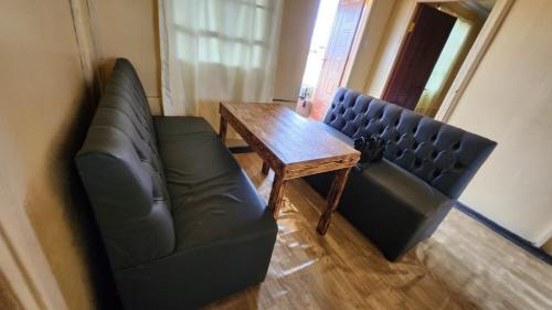 two leather chairs and a wooden table in a room at Amanya 2 Bedroom Self Catering Tent in Amboseli