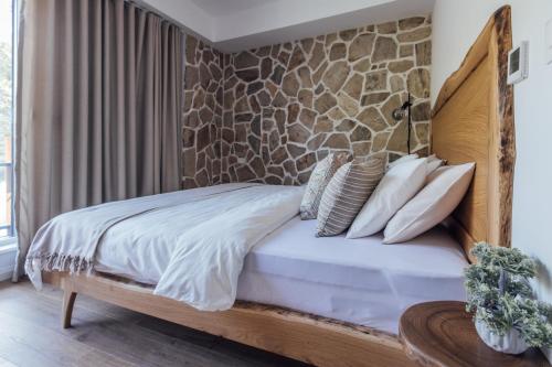 a bedroom with a bed with a stone wall at Timeless Appartment in Mavrovo