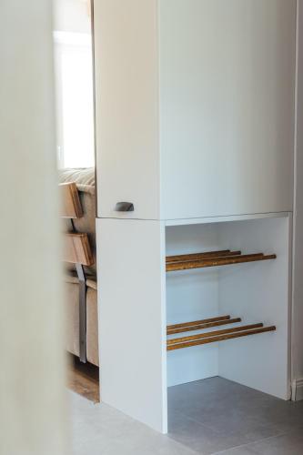 a white refrigerator in a living room next to a couch at Timeless Appartment in Mavrovo
