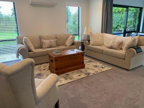 a living room with two couches and a coffee table at The Gate House in Tauranga