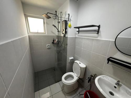 a white bathroom with a toilet and a sink at Casa D'Faiz Alanis near KLIA pool olympic size in Sepang