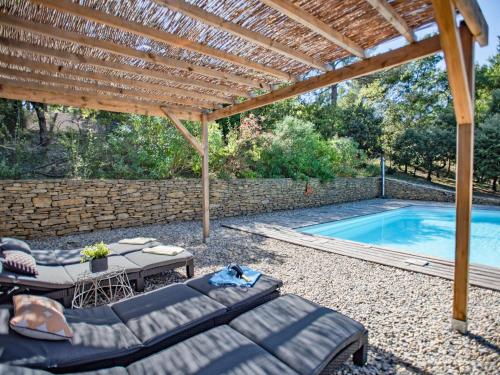 une terrasse avec une pergola et une piscine dans l'établissement La grande Pinède, à Faucon