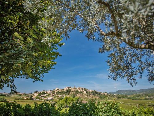 a town on top of a hill with trees at La Pinede in Faucon